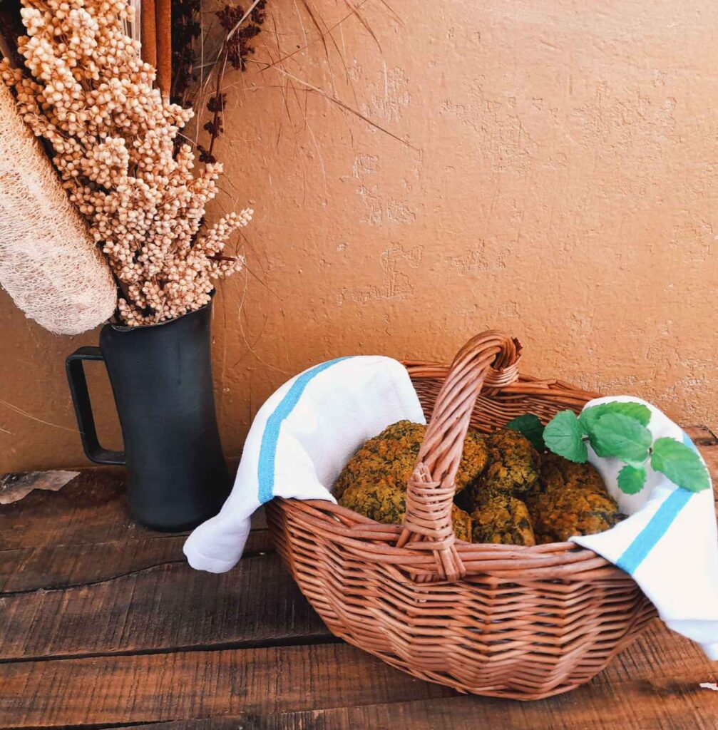 Une photographie d'un panier en osier rempli de boulettes salées avec un vase à sa gauche