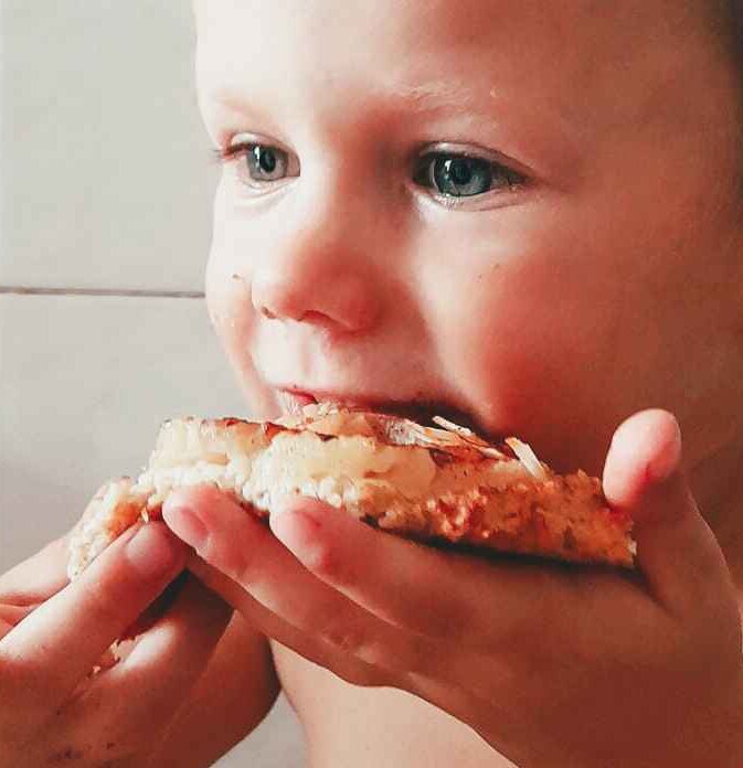 Photographie d'un enfant croquant dans une tarte