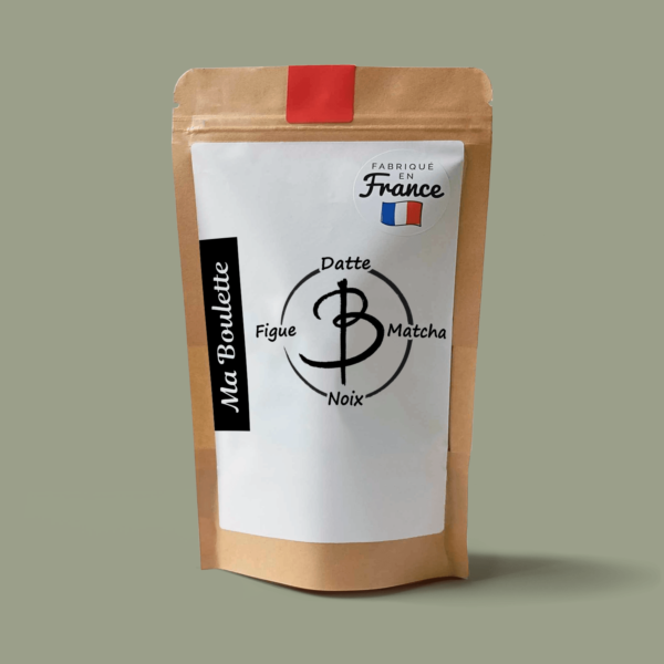 Une photographie commerciale du produit energy balls Figue-Noix-Matcha sur un fond vert. Le produit est contenu dans un sachet craft avec une étiquette contenant l'inscription "Fabriqué en France"