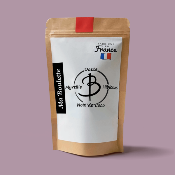Une photographie commerciale du produit energy balls Myrtille-Noix de Coco-Hibiscus sur un fond mauve. Le produit est contenu dans un sachet craft avec une étiquette contenant l'inscription "Fabriqué en France"